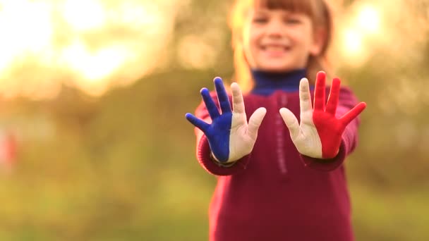 Joyful meisje zwaaien handen geschilderd in Frankrijk vlag kleuren en zeg hallo buiten bij zonsondergang - Video