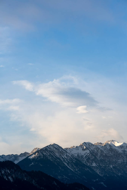 Mountain range around the Schwarzhanskarspitze mountain in vertical format in winter with gentle soft clouds and blue sky - Fotografie, Obrázek