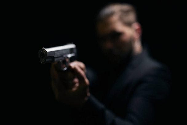 Blur background of gangster holding gun - 写真・画像