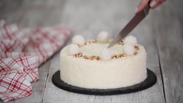 Cutting a delicious coconut mousse cake, decorated with candy and almond. - Footage, Video