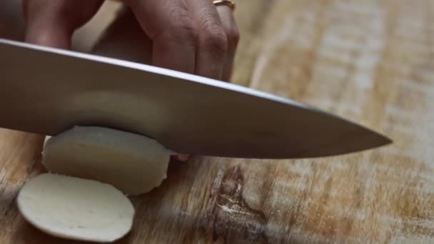 Ahşap bir kesme tahtasında mozarella peyniri dilimleyen kadın elleri. 4k video - Video, Çekim