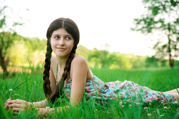 ładną dziewczyną o piękny uśmiech jest pozowanie na trawie - Zdjęcie, obraz