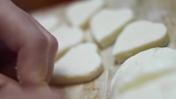 Ahşap kesme tahtasının üzerinde kalp şeklinde mozzarella peyniri kesen kadın elleri. Sevgililer Günü için yemek hazırlıyorum. 4K video. Sanatsal çekim - Video, Çekim