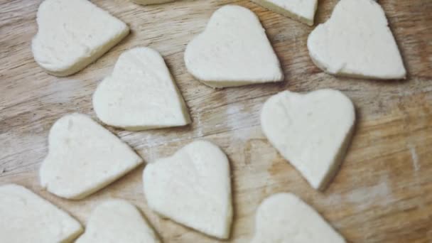 Ahşap kesme tahtasındaki mozarella peynirinin kalp şekilleri. 4K video. Sevgililer Günü için yemek hazırlıyorum. Döndürme, üst görünüm - Video, Çekim