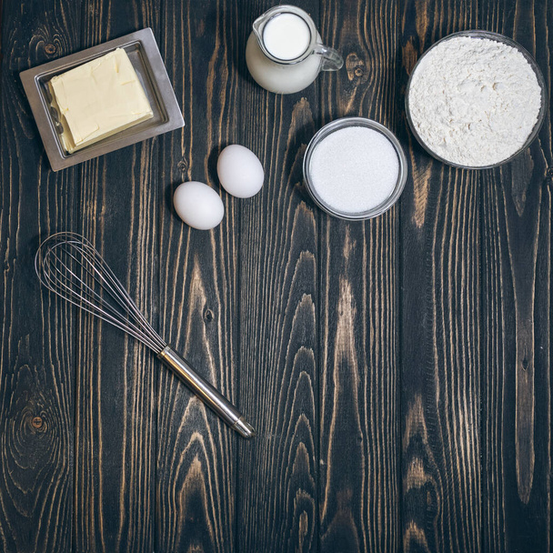 πάνω άποψη του αλεύρου, eegs, γάλα και ζάχαρη στο γραφείο στην κουζίνα - Φωτογραφία, εικόνα