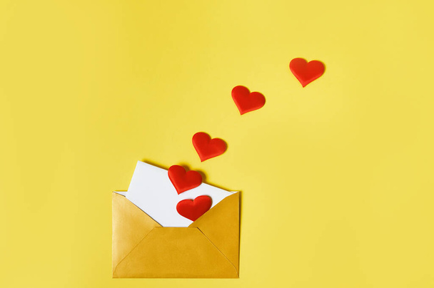 Avattu kultainen kirjekuori, jossa on sydämiä ja rakkauskirje. Saint Ystävänpäivä käsite - Valokuva, kuva