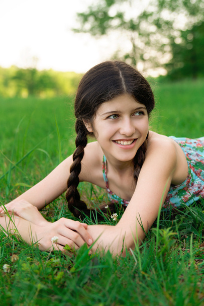 Niza chica con hermosa sonrisa está posando en la hierba
 - Foto, imagen