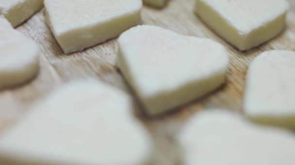 Forma de corazón de queso mozzarella en una tabla de cortar de madera. Vídeo 4k. Preparando comida para el Día de San Valentín. Primer plano - Imágenes, Vídeo