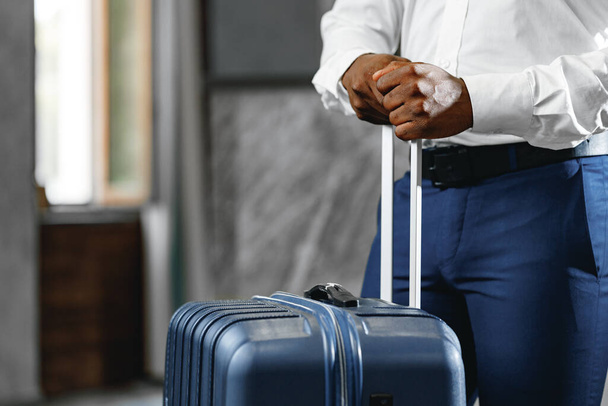 Unrecognizable businessman standing with luggage suitcase in hotel lobby - Photo, Image