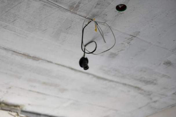vieja lámpara halógena colgando en cables eléctricos de placas de yeso falso techo - Foto, imagen
