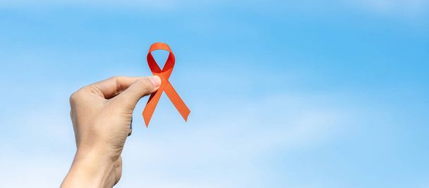 Leukémia, veserák nap, sclerosis multiplex, CRPS, önkárosító tudatosság hónapja, Orange Ribbon az emberek életének és betegségének támogatására. Egészségügyi ellátás és a rák világnapja koncepció - Fotó, kép