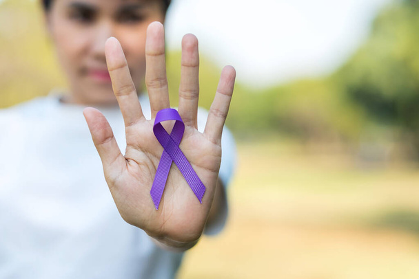 Pancreatic Cancer, world Alzheimer, epilepsy, lupus and domestic violence day Awareness month, Woman holding purple Ribbon for supporting people living. Healthcare and World cancer day concept - Photo, image