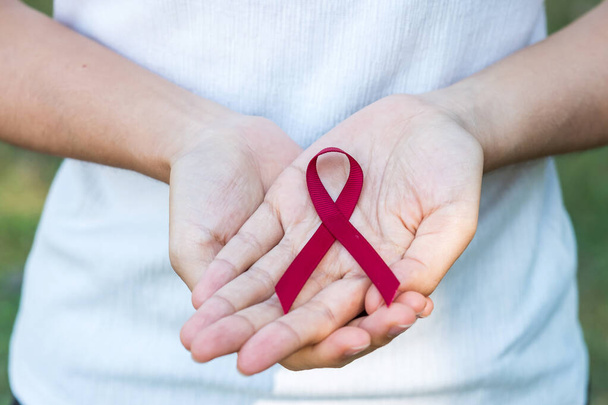 Borgonha Red Ribbon para apoiar as pessoas que vivem e doença. Saúde e conceito de sexo seguro. Dezembro Dia Mundial da SIDA e mieloma múltiplo mês de Consciência do Câncer - Foto, Imagem