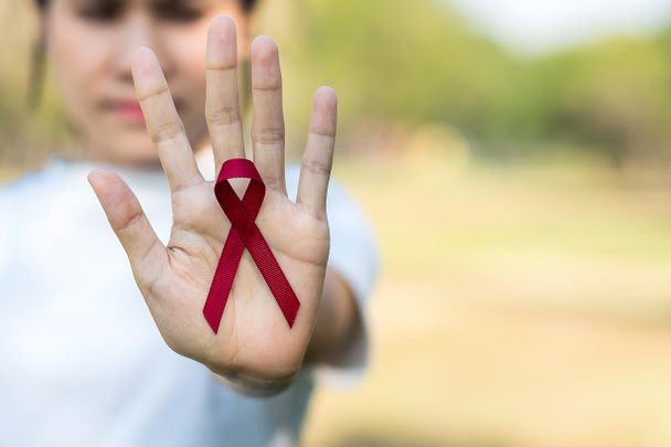 Burgundská červená stuha na podporu lidí žijících a nemocných. Zdravotní péče a bezpečný sex koncept. Prosince World Aids Day a mnohočetný myelom Cancer Awareness month - Fotografie, Obrázek