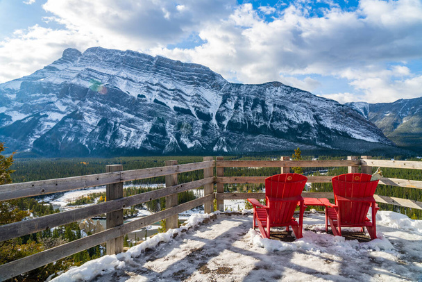 Kırmızı sandalye, güneşli kış gününde Rundle Dağı 'nın üstünden bakıyor. Banff Ulusal Parkı. Güzel manzara. Serseriler, Kanadalı Kayalıklar. - Fotoğraf, Görsel