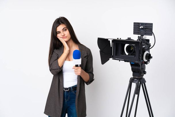 Reportera mujer sosteniendo un micrófono y reportando noticias sobre aislado fondo blanco infeliz y frustrado - Foto, imagen
