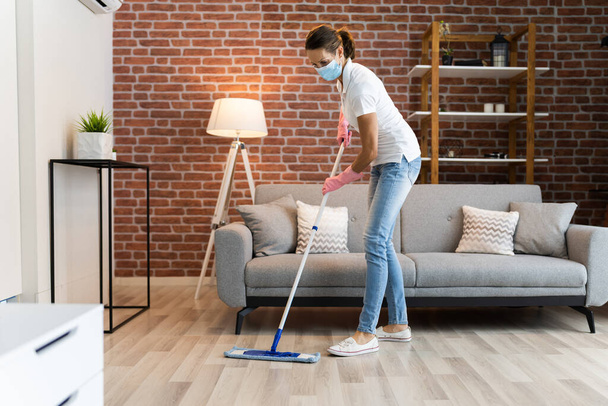 Woman Cleaning The Hardwood Floor With Mop In Face Mask - Фото, изображение