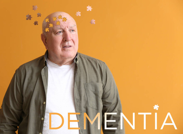 Starší muž trpící mentálním postižením na barevném pozadí - Fotografie, Obrázek