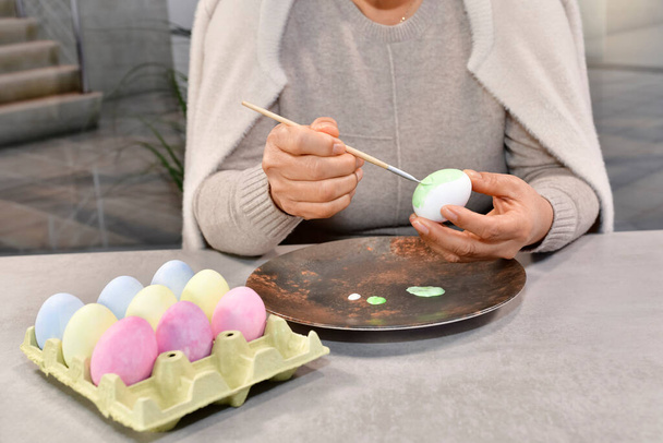 Manos femeninas pintando un huevo con un pincel - Foto, Imagen