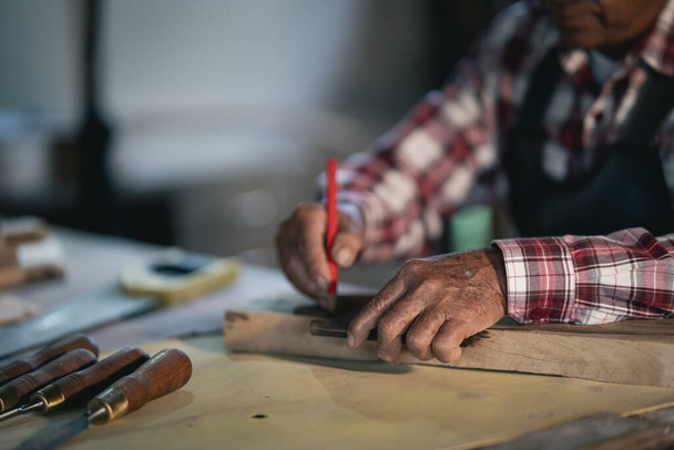 Carpintero trabajando en madera en carpintería. el hombre trabaja en una carpintería - Foto, Imagen