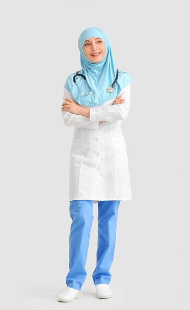 Portrait of female Muslim doctor on light background - Foto, immagini
