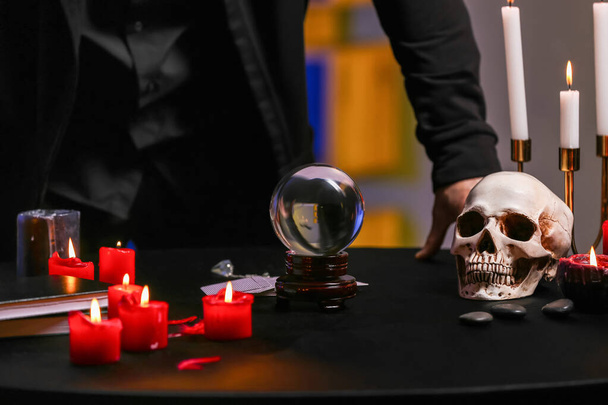 Velas, bola de cristal y cráneo humano en la mesa de adivino - Foto, Imagen