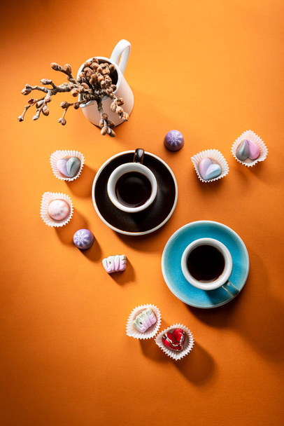 Two cups of coffee and chocolate candies on bold surface - Fotografie, Obrázek