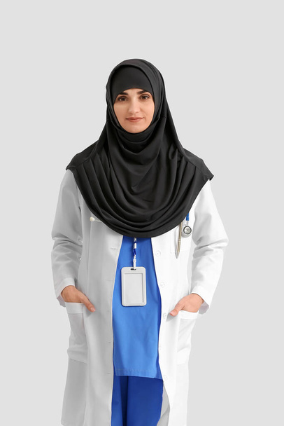Portrait of female Muslim doctor on light background - Fotó, kép