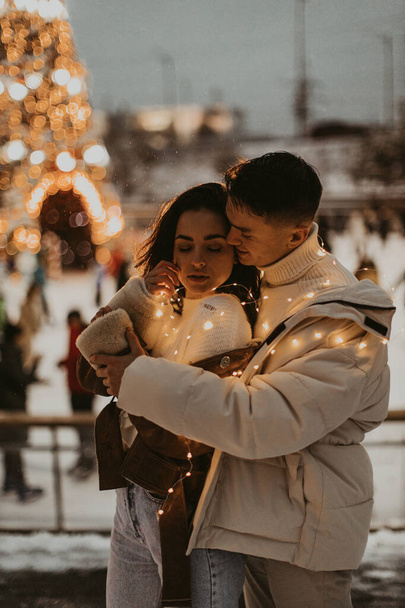 Young romantic couple in love outdoors in winter before Christmas.  Two lovers are hugging and kissing in Saint Valentine's Day. - Photo, Image