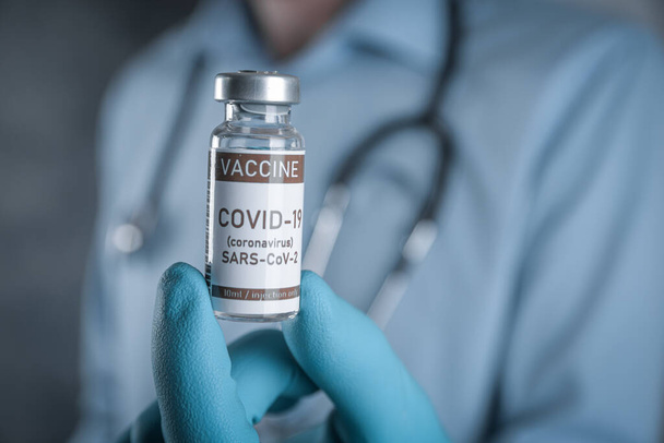 Médico con un estetoscopio en el hombro en la mano COVID-19, coronavirus, vacuna SARS-cov-2. Salud y concepto médico.Desarrollo y creación de vacunas. - Foto, imagen