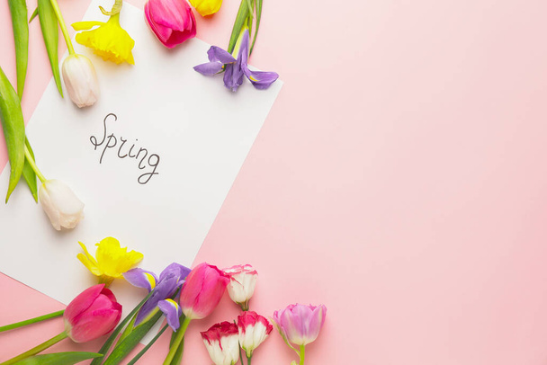 Beautiful flowers and paper with text SPRING on color background - Fotoğraf, Görsel
