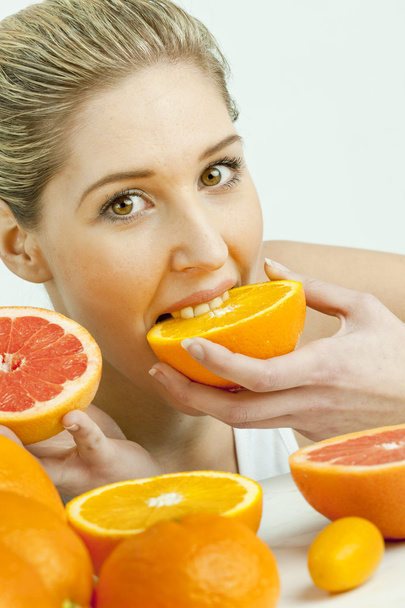 オレンジを食べる若い女性の肖像画 - 写真・画像