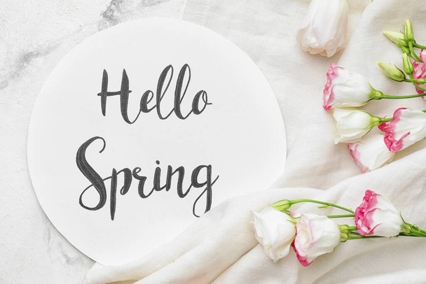 Beautiful flowers and card with text HELLO SPRING on light background - Φωτογραφία, εικόνα