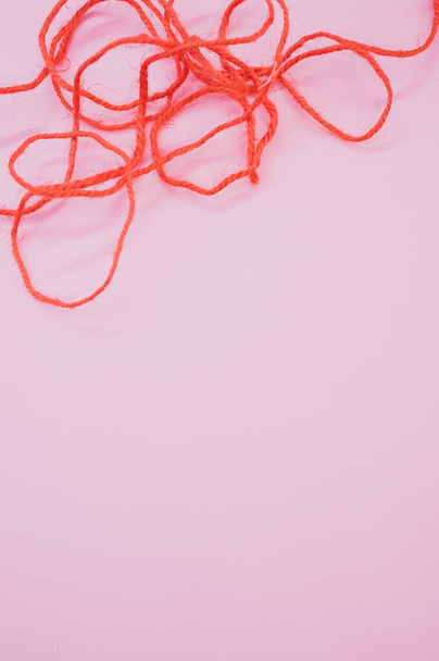 A vertical shot of bright red threads on a purple background - Photo, image