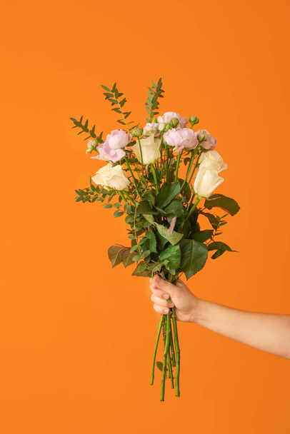 Hand with bouquet of beautiful flowers on color background - Fotoğraf, Görsel