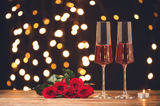 Бокалы шампанского, цветы и свечи на столе. Празднование Дня Святого Валентина - Фото, изображение