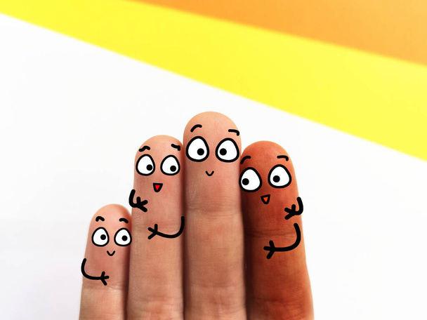 Cuatro dedos están decorados como cuatro personas. Tienen diferentes colores de piel. Tienen una buena relación.. - Foto, Imagen