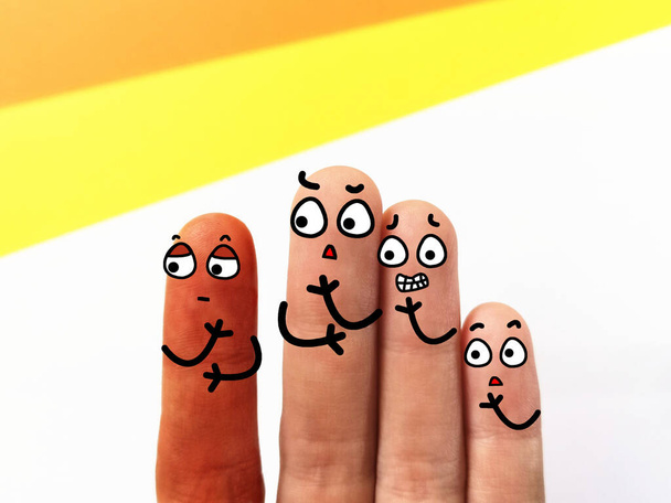 Cztery palce są urządzone jako cztery osoby. Trzech z nich dyskryminuje przyjaciela, który ma inny kolor skóry.. - Zdjęcie, obraz