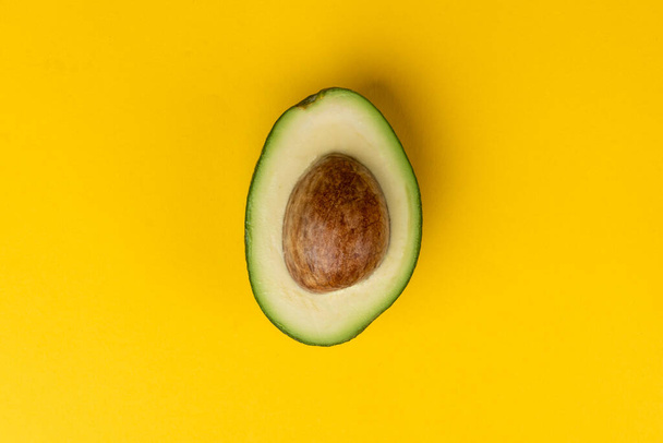 Avocado fruit on yellow background. - Фото, зображення