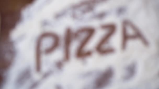 la palabra pizza está escrita en harina blanca sobre harina blanca. - Imágenes, Vídeo