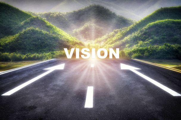 Vision word behind arrow sign for give direction on empty asphalt road with sunrise on mountain background. Future ahead recovery concept and keep trying idea - Photo, Image