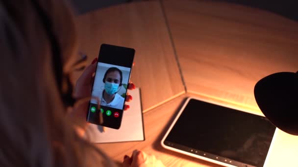 Video konferans uygulaması üzerinden doktoruyla konuşmak için akıllı telefonu kullanan evde hasta bir kız. Çevrimiçi Görüntü Sohbeti Kullanılarak, Güzel Kadın Profesyonel Doktorla Olası Semptomları Denetliyor - Video, Çekim