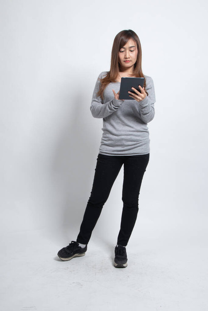 Young Asian woman with a computer tablet on white background - Valokuva, kuva