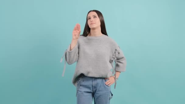Gelangweilte Frau macht blah blah Geste mit der Hand, isoliert auf türkisfarbenem Hintergrund. - Filmmaterial, Video