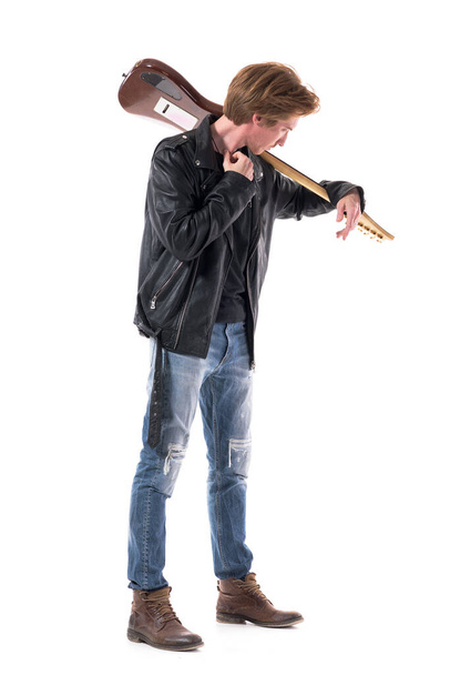 Side view of pensive rock musician carrying electric guitar on shoulder looking away. Full body isolated on white background.  - Fotoğraf, Görsel