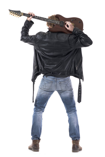 Rückenansicht eines männlichen Rockgitarristen, der auf seinen Schultern E-Gitarre spielt. Ganzkörper isoliert auf weißem Hintergrund.  - Foto, Bild