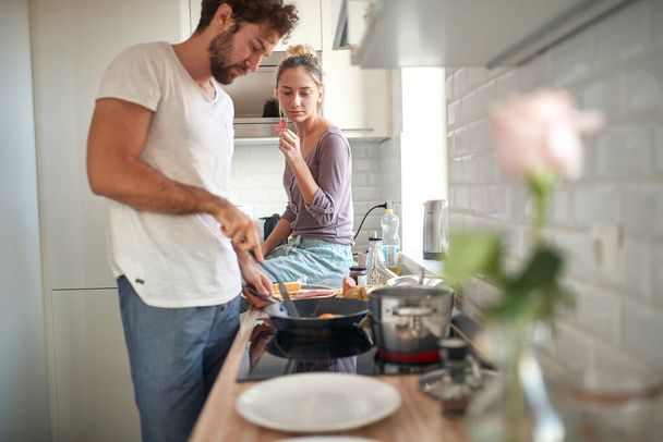 A young couple in love preparing breakfast on a beautiful morning in the kitchen. Cooking, together, kitchen, relationship - Foto, imagen