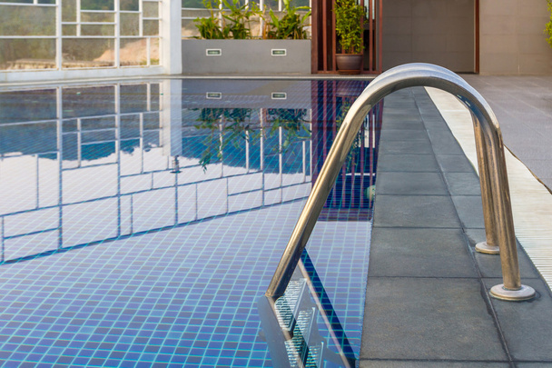 Reflexão de água, piscina com escada de aço
. - Foto, Imagem
