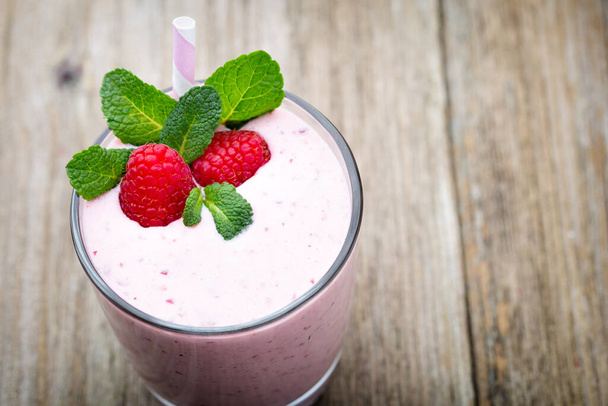 Raspberry milk shake with mint decor. - Zdjęcie, obraz