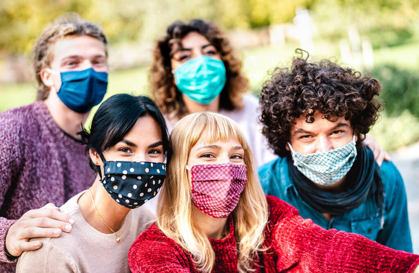 Мультирасовые люди, делающие селфи в маске для лица и весенней одежде - Новая концепция нормального образа жизни с молодыми друзьями, веселящимися вместе на улице - Фильтр Брайта с акцентом на центральной девушке - Фото, изображение